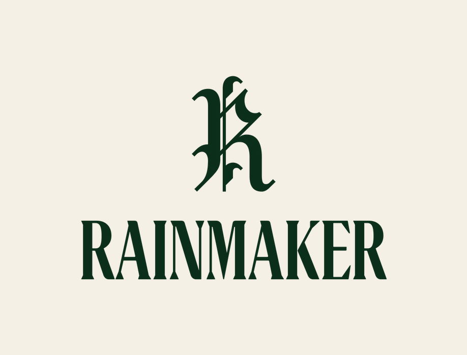 The primary Rainmaker lockup: monogram and wordmark in forest green on cream. The default logo.