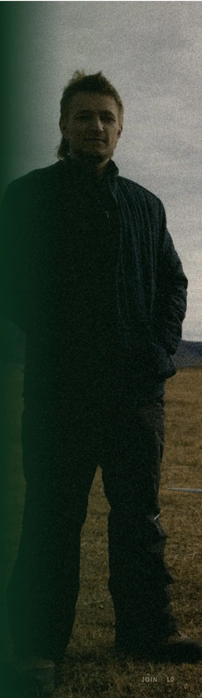 A Rainmaker operator stands in a winter field under a grey sky, Bear River Basin behind him.