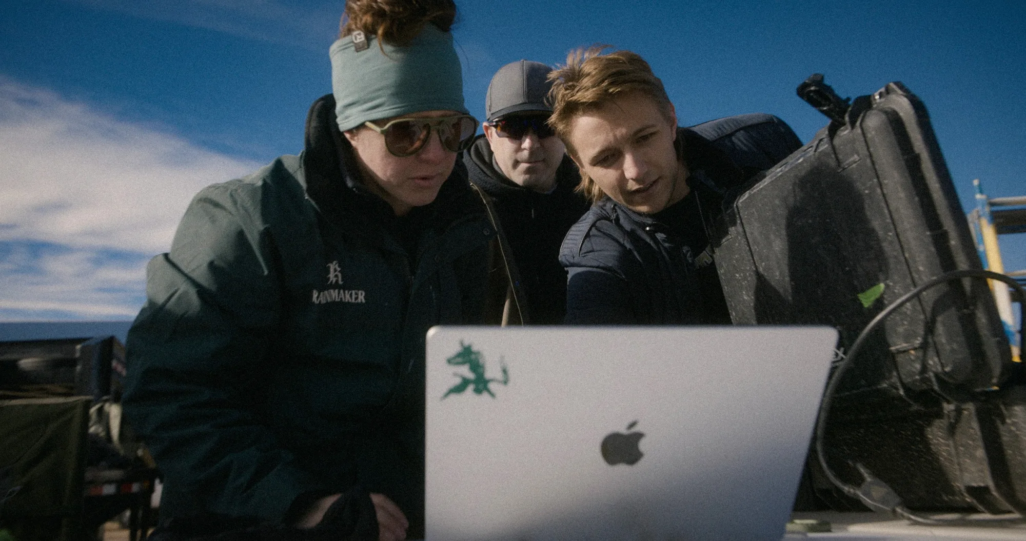 Three operators over a laptop between storm cells.